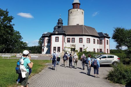 Eine Gruppe von Pilgern gehen auf eine Kirche zu.