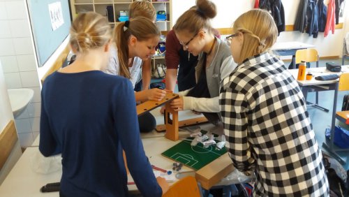 Mehrere Schüler beugen sich über den Tischwuzzler, den sie gerade aufbauen