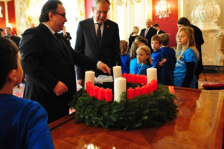 Bundespräsident Alexander Van der Bellen (Mitte) freute sich über den Adventkranz von Diakonie-Direktor Michael Chalupka und die musikalische Begleitung des Kinderchors der Johann Sebastian Bach Musikschule. Foto: epd/M. Uschmann