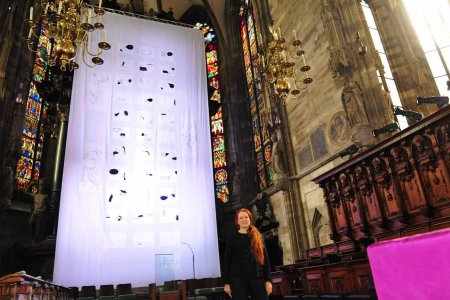   Die aus Kärnten stammende evangelische Künstlerin Lisa Huber vor dem von ihr gestalteten Fastentuch im Wiener Stephansdom. Foto: epd/M. Uschmann