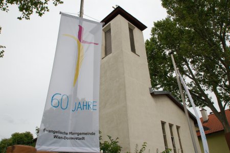 Fahner mit dem Kirchenlogo und einem aufgemalten Schriftzug &quot;60 Jahre&quot;