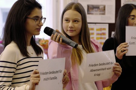 Schüler*innen mit Friedensbotschafen beim Projekt „optimis-TISCH – In eine friedliche Zukunft“