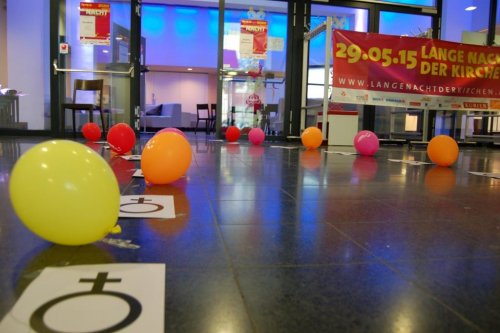 Der Weg zum Saal ist gesäumt mit Luftballons und Venussymbolen.
