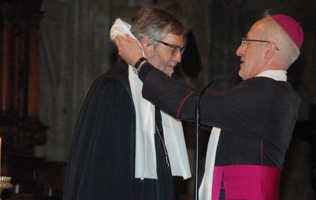 Weihbischof Franz Scharl legt Superintendent Hansjörg Lein die weiße Stola um, die jeder Teilnehmende am ökumenischen Gottesdienst trug.
