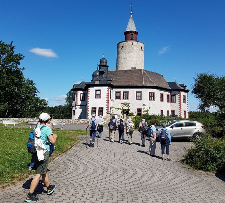 Eine Gruppe von Pilgern gehen auf eine Kirche zu.